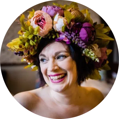 Emma laughing, wearing a crown of peonies and foliage.