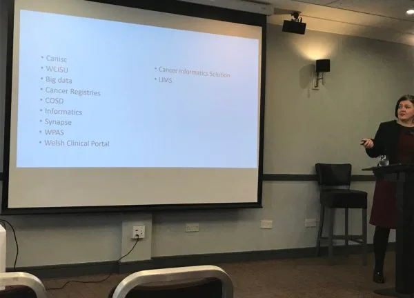 A conference slide listing the many separate cancer data systems in use, among them Canisc, WCISU, COSD and the cancer registry, none of which talk to each other.