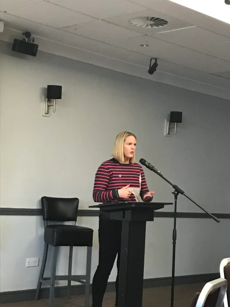 A speaker addressing the conference from the lectern.