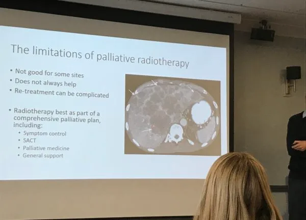 A conference slide on the limitations of palliative radiotherapy, beside a scan: not good for some sites, does not always help, and re-treatment can be complicated.