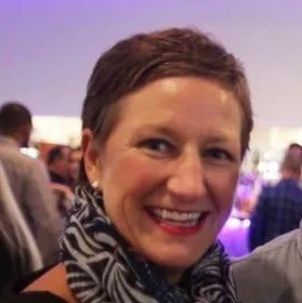 Jo Taylor, who founded METUPUK, smiling at an evening event.