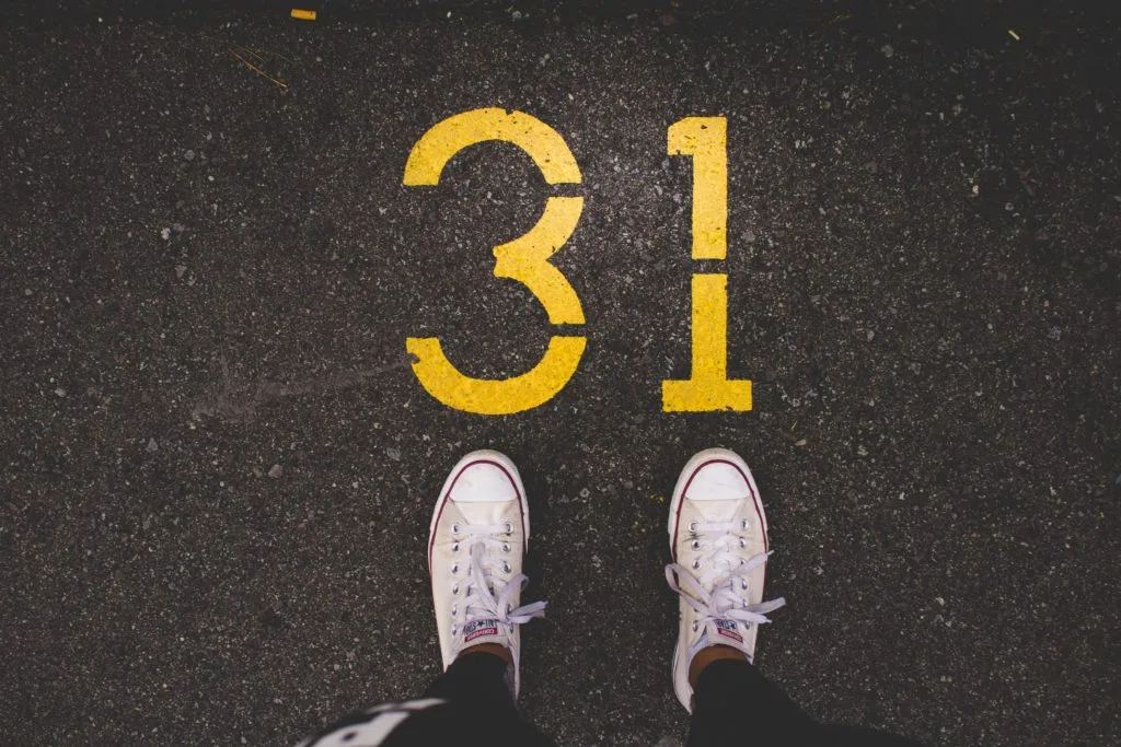 Pair of trainers in front of the number 31 painted on the road