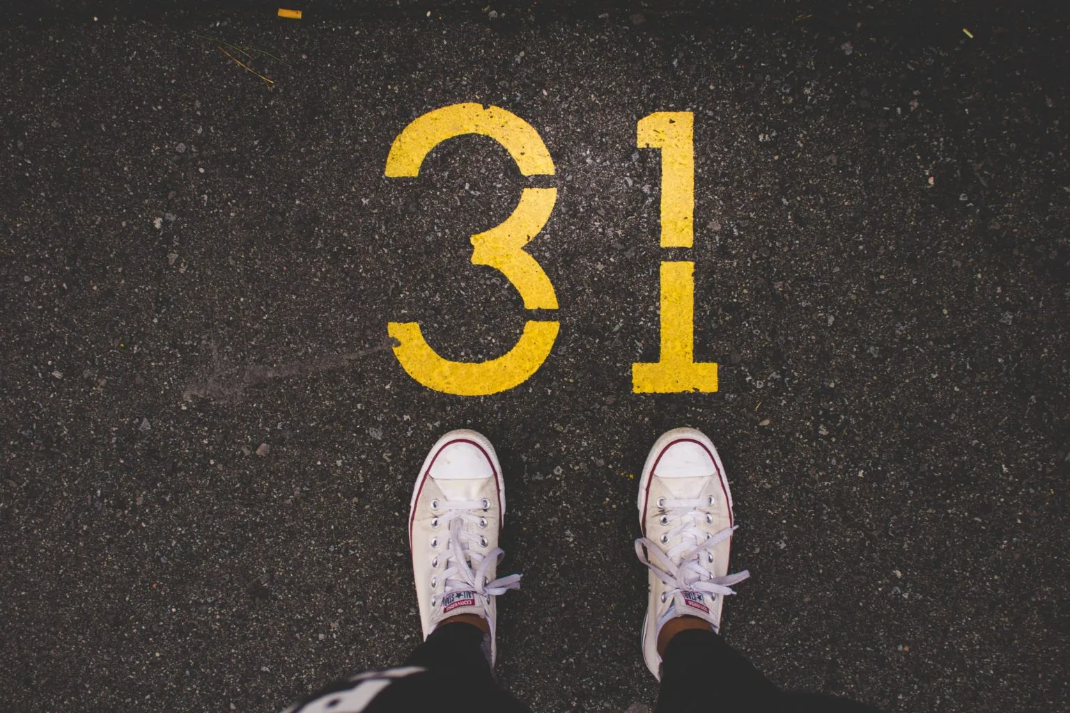 Pair of trainers in front of the number 31 painted on the road