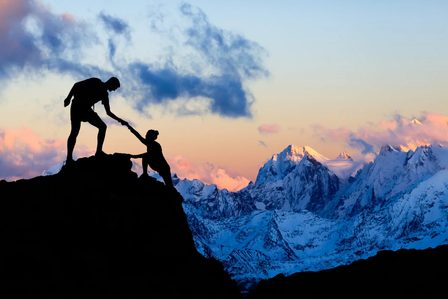 <p>Teamwork couple helping hand, trust in mountains. Team of climbers man and woman hiking, help each other on top of mountain, climbing together, inspiring sunset on Elbrus, Russia.</p>